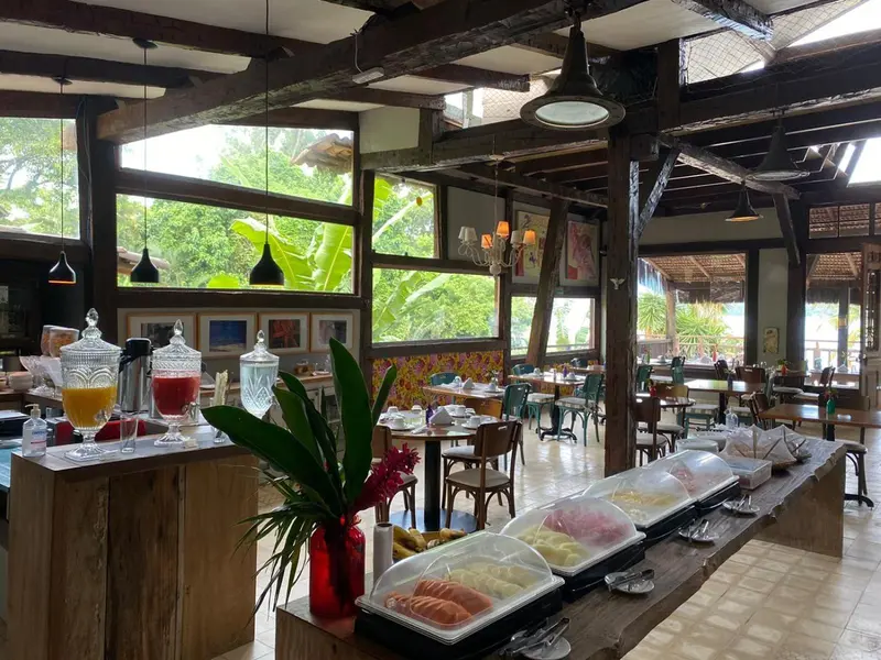 Une salle lumineuse propose un buffet varié avec des pâtisseries et des boissons.