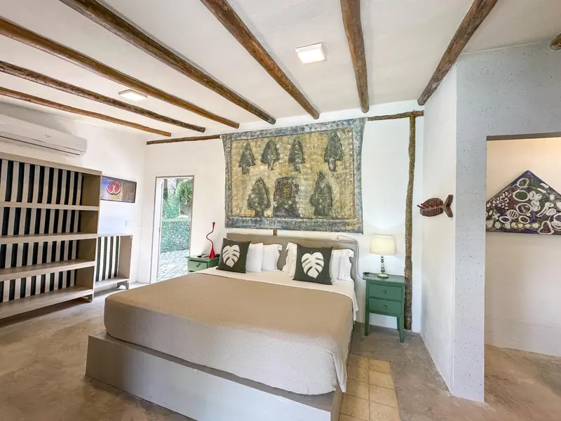 Une chambre lumineuse avec un lit double et une décoration murale.