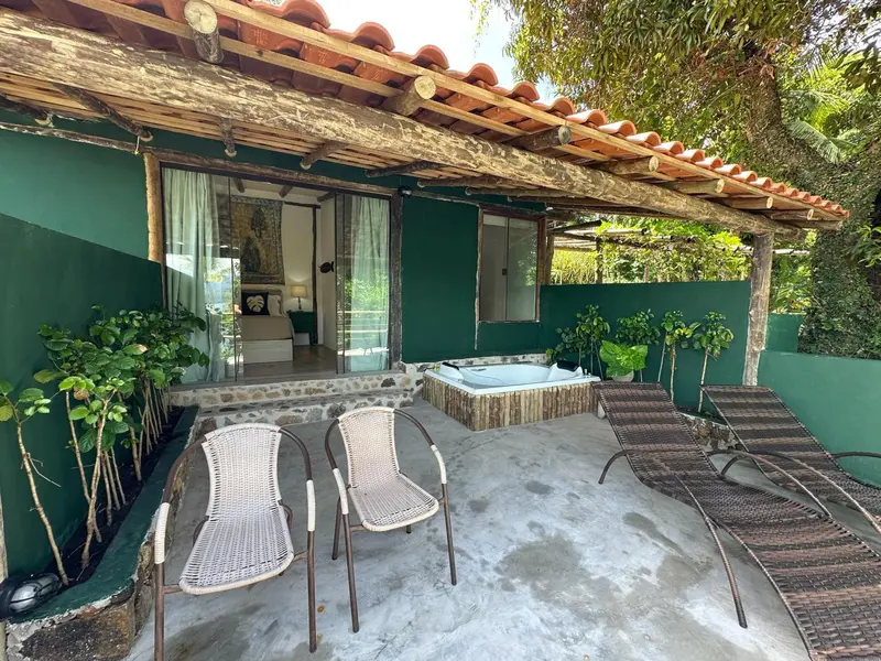 Terrasse ombragée avec jacuzzi et mobilier de jardin.
