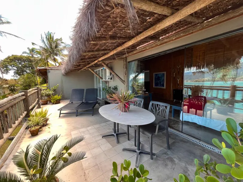 Terrasse aménagée avec mobilier de jardin et vue sur la mer.
