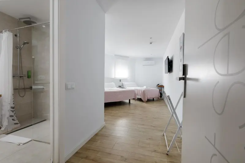 Chambre lumineuse avec un lit et une douche à l'italienne.