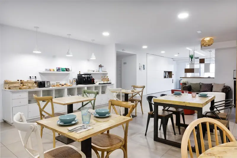 Une salle lumineuse avec des tables et des chaises pour le petit-déjeuner.