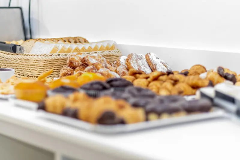 Présentation de viennoiseries et de pâtisseries sur un buffet.