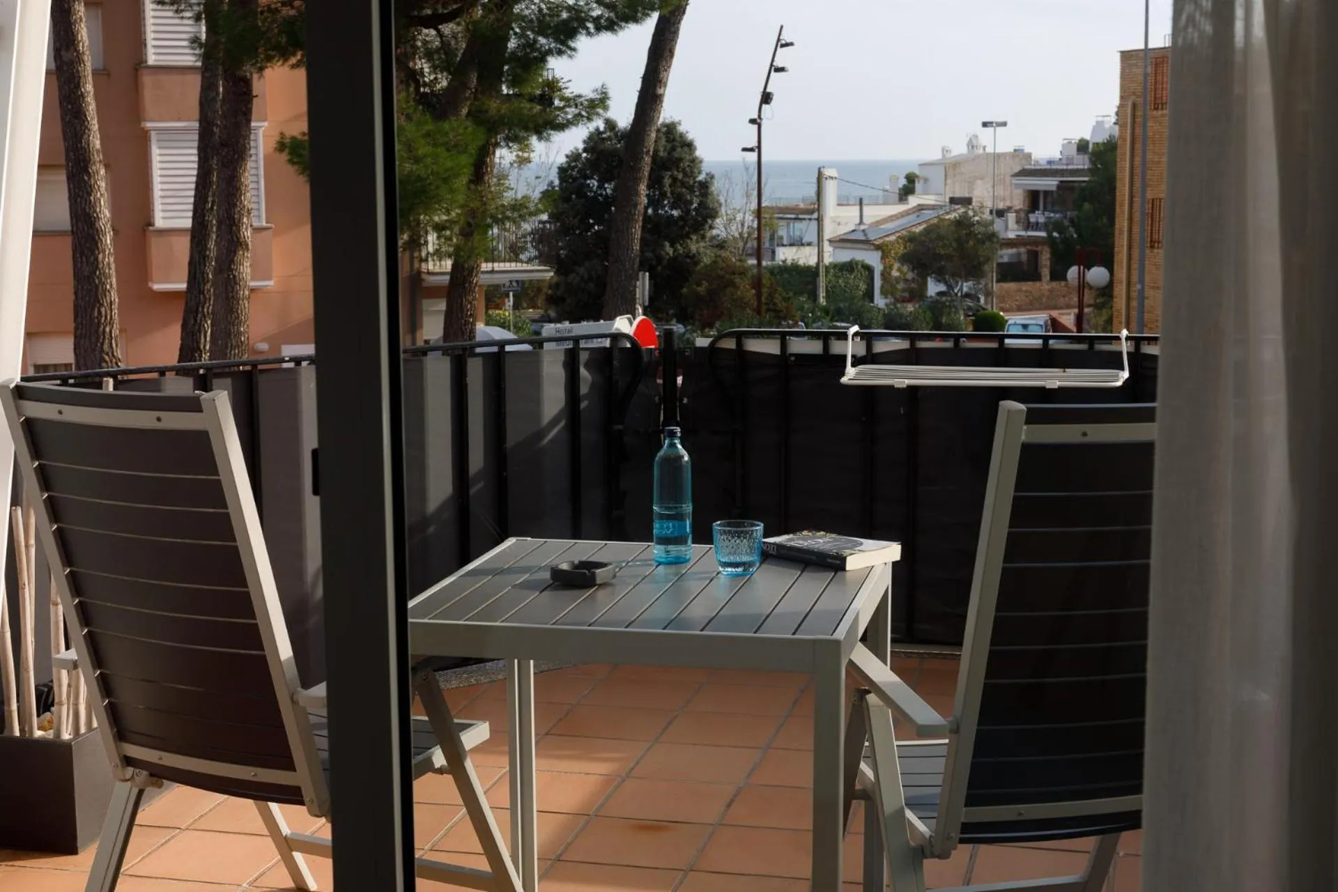 Une terrasse avec deux fauteuils et une table basse donnant sur la mer.