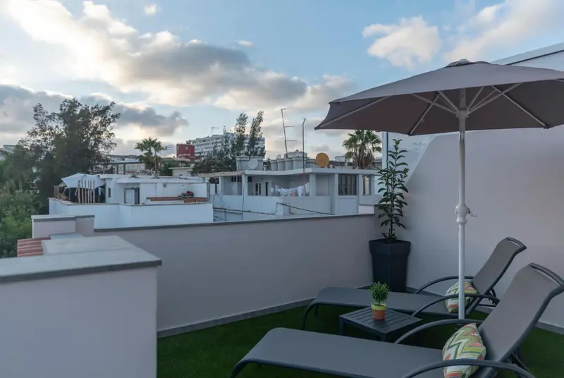 Terrasse aménagée avec des transats et des plantes.