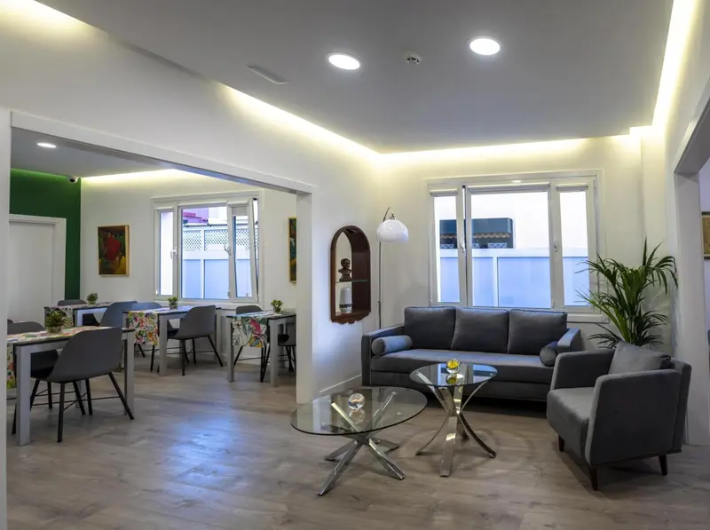 Espace de séjour lumineux avec canapés et table à manger.
