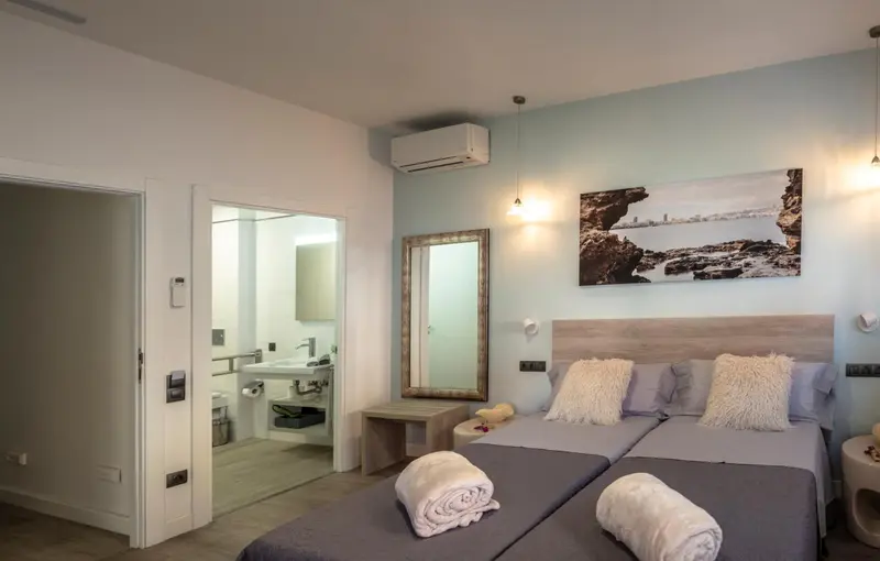 Chambre avec deux lits simples et un grand miroir.