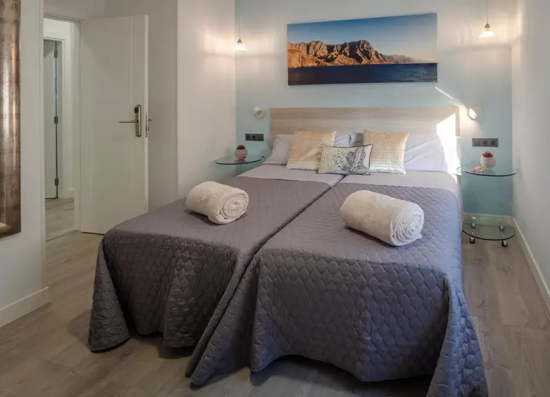 Une chambre lumineuse avec deux lits simples et une décoration moderne.