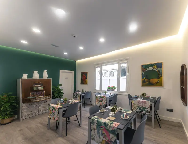 Une salle lumineuse avec des tables dressées pour le repas.