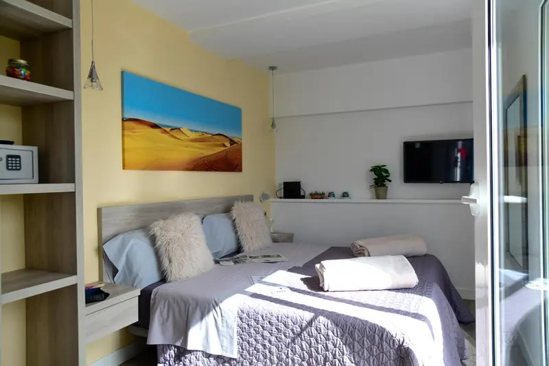 Une chambre lumineuse avec un grand lit et une décoration murale.
