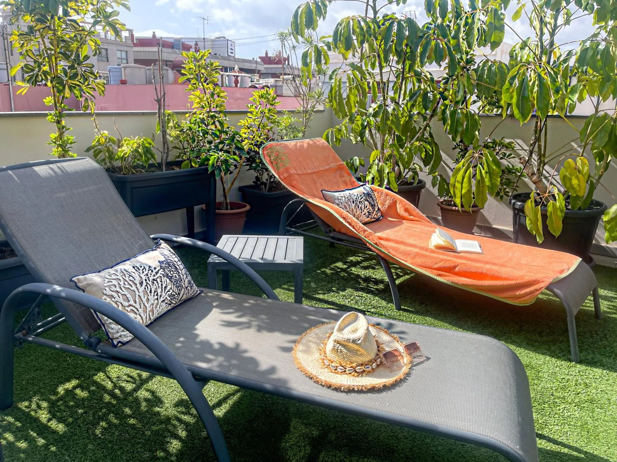 Transats et plantes ornent une terrasse ensoleillée.