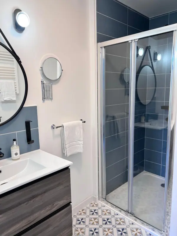 Une salle de bain moderne avec une douche vitrée et un lavabo.