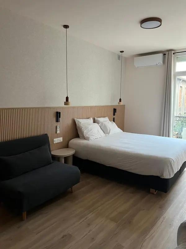 Une chambre lumineuse avec un grand lit et un canapé.
