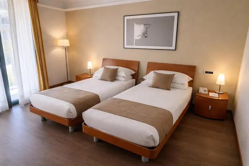 Une chambre lumineuse avec deux lits simples et une décoration sobre.