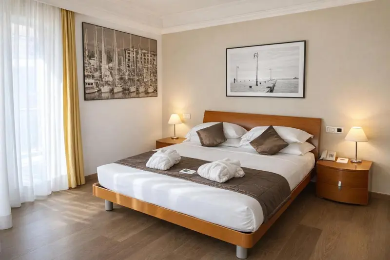Une chambre lumineuse avec un grand lit et des œuvres d'art murales.