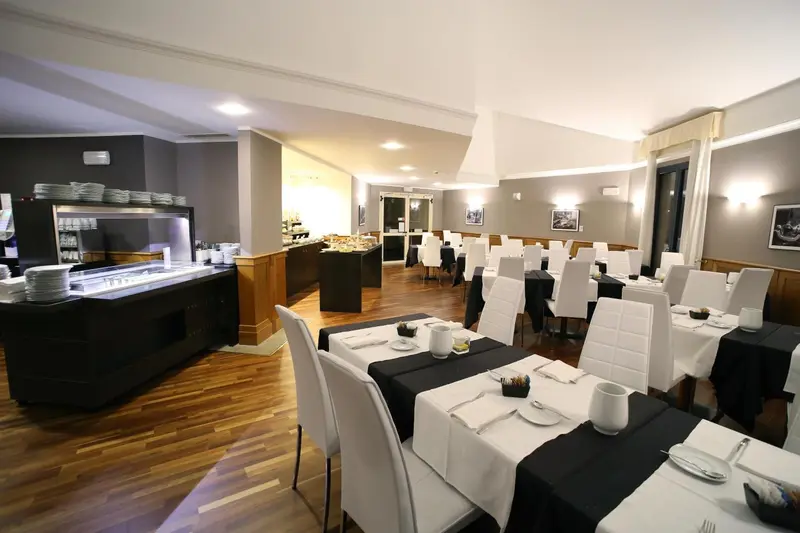 Une salle lumineuse avec des tables dressées pour le repas.