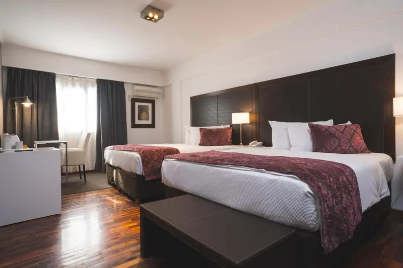 Une chambre avec deux lits doubles et une décoration sobre.