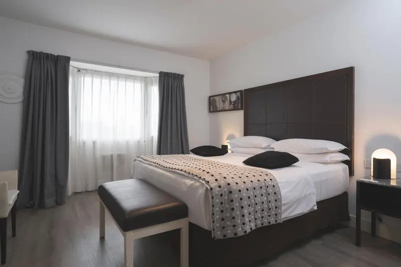 Une chambre moderne avec un grand lit et des rideaux gris.