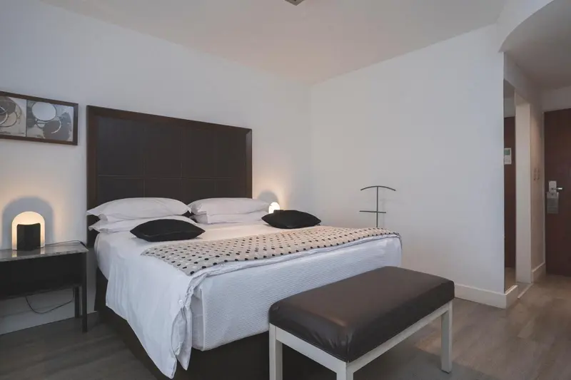 Une chambre moderne avec un grand lit recouvert d'une courtepointe à motifs.