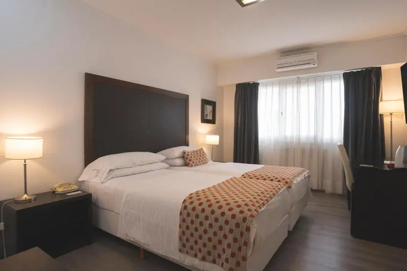 Une chambre lumineuse avec un grand lit et des tables de chevet.