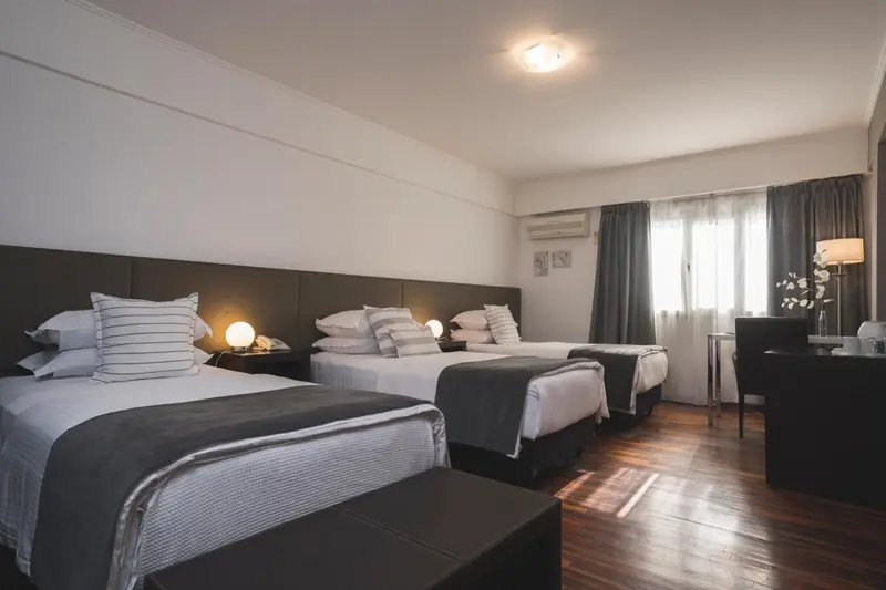 Une chambre d'hôtel avec deux lits simples et une table de chevet.