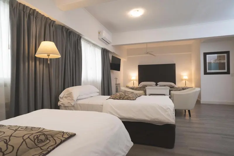 Une chambre lumineuse avec deux lits simples et un coin salon.