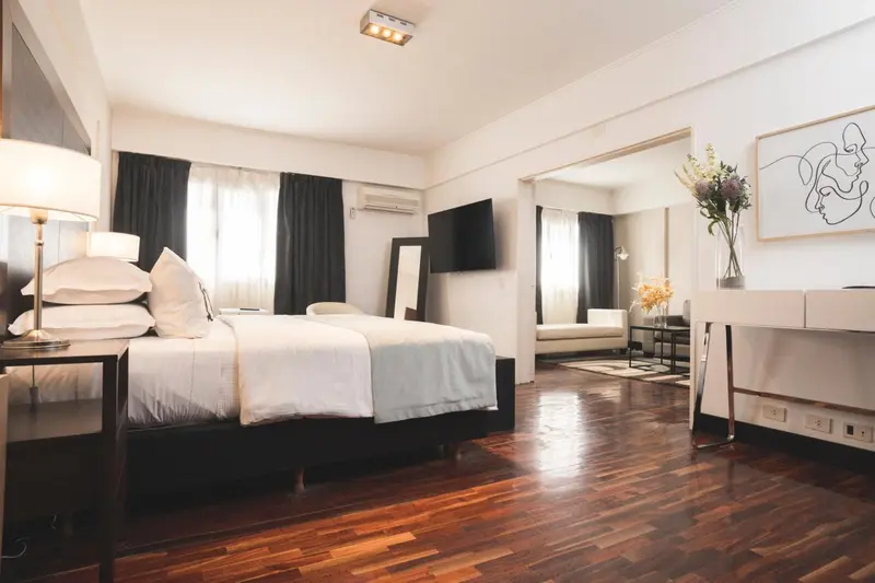 Une chambre lumineuse avec un grand lit et un espace détente.