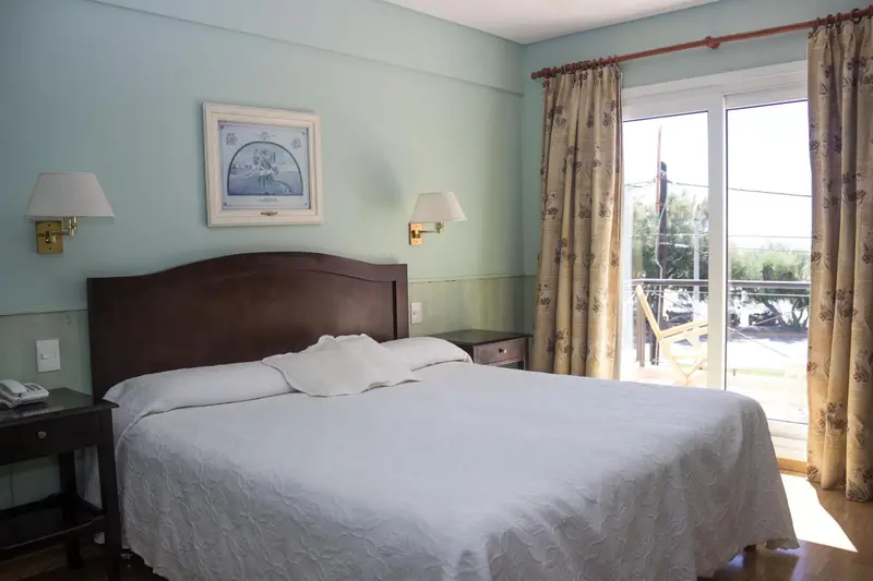 Une chambre lumineuse avec un grand lit et un accès à une terrasse.