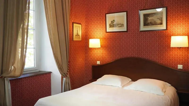 Une chambre à coucher avec un lit double et des tableaux au mur.