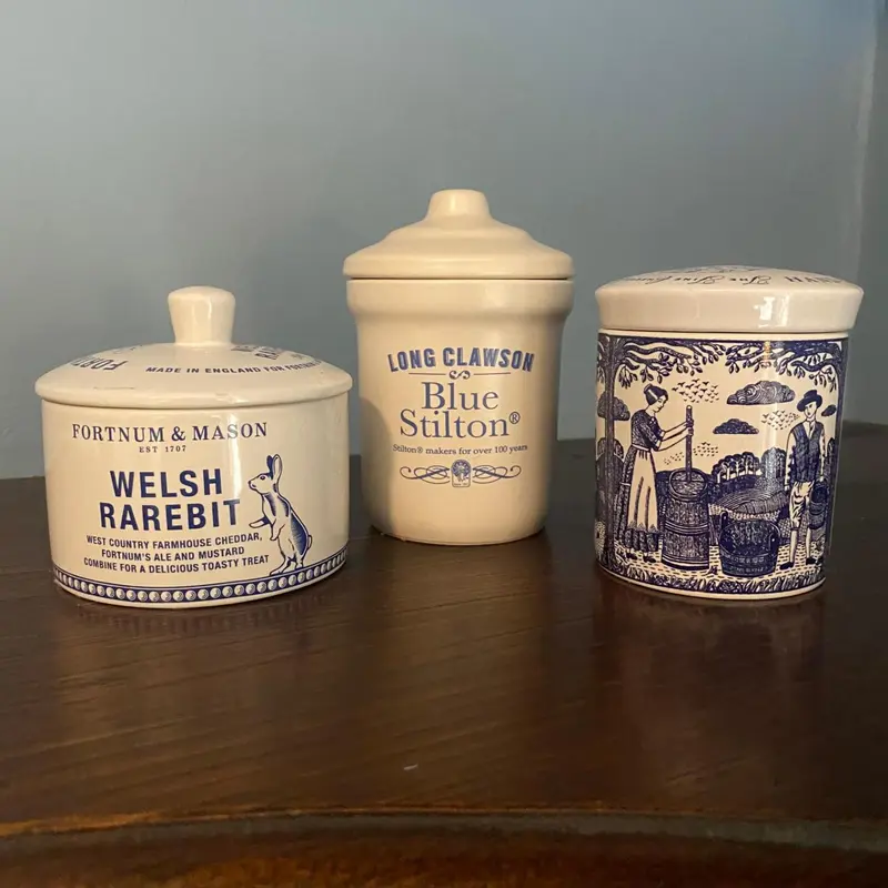 Trois pots en céramique décoratifs sont alignés sur une surface en bois.