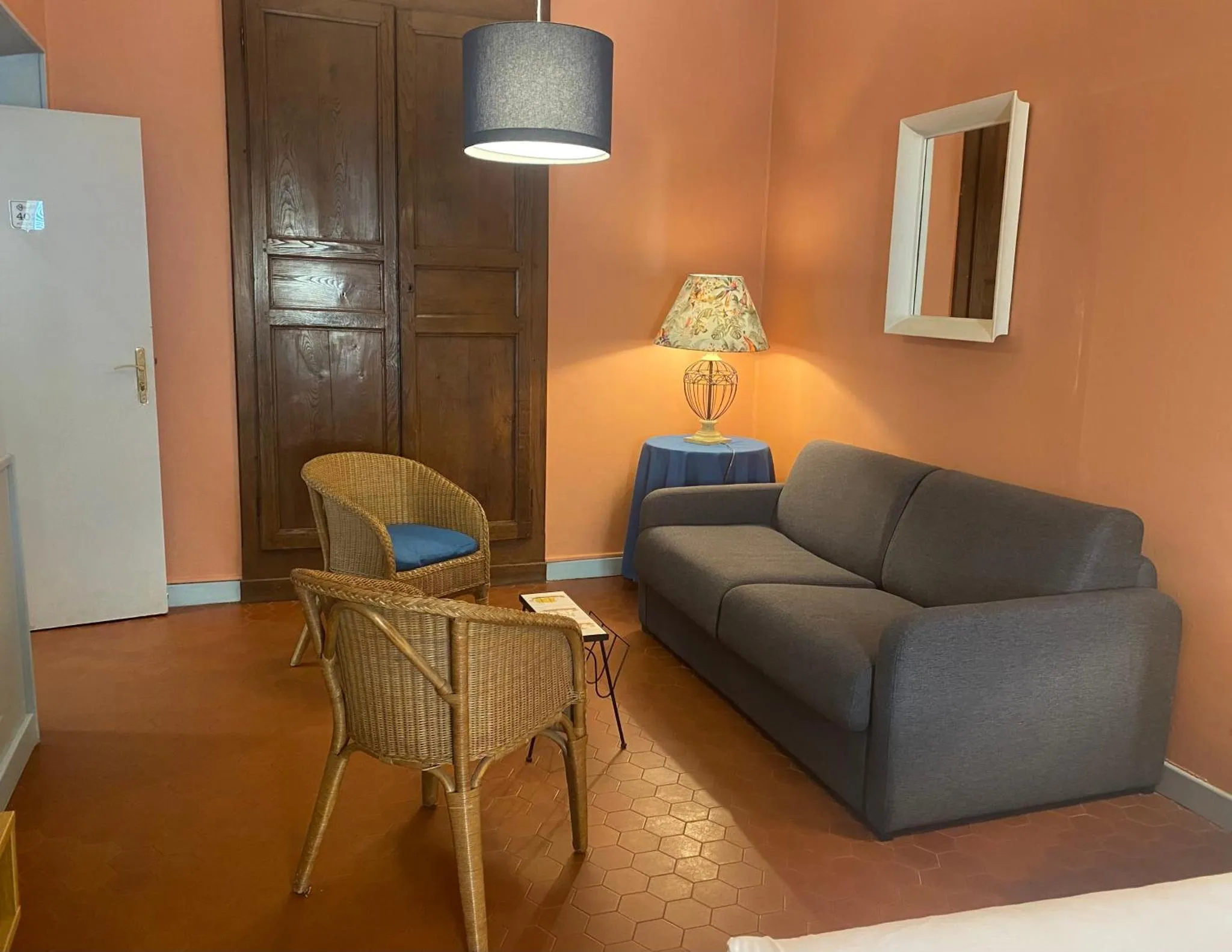 Espace de détente intérieur avec canapé et fauteuils en rotin.