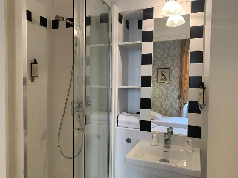 Une douche à l'italienne avec un lavabo et des étagères intégrées.