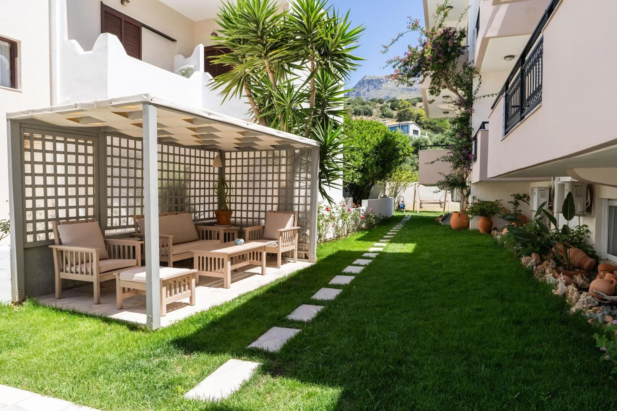 Un espace de détente extérieur avec des meubles de jardin et une pelouse verdoyante.