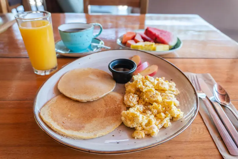 Un petit-déjeuner copieux est présenté sur une table en bois.