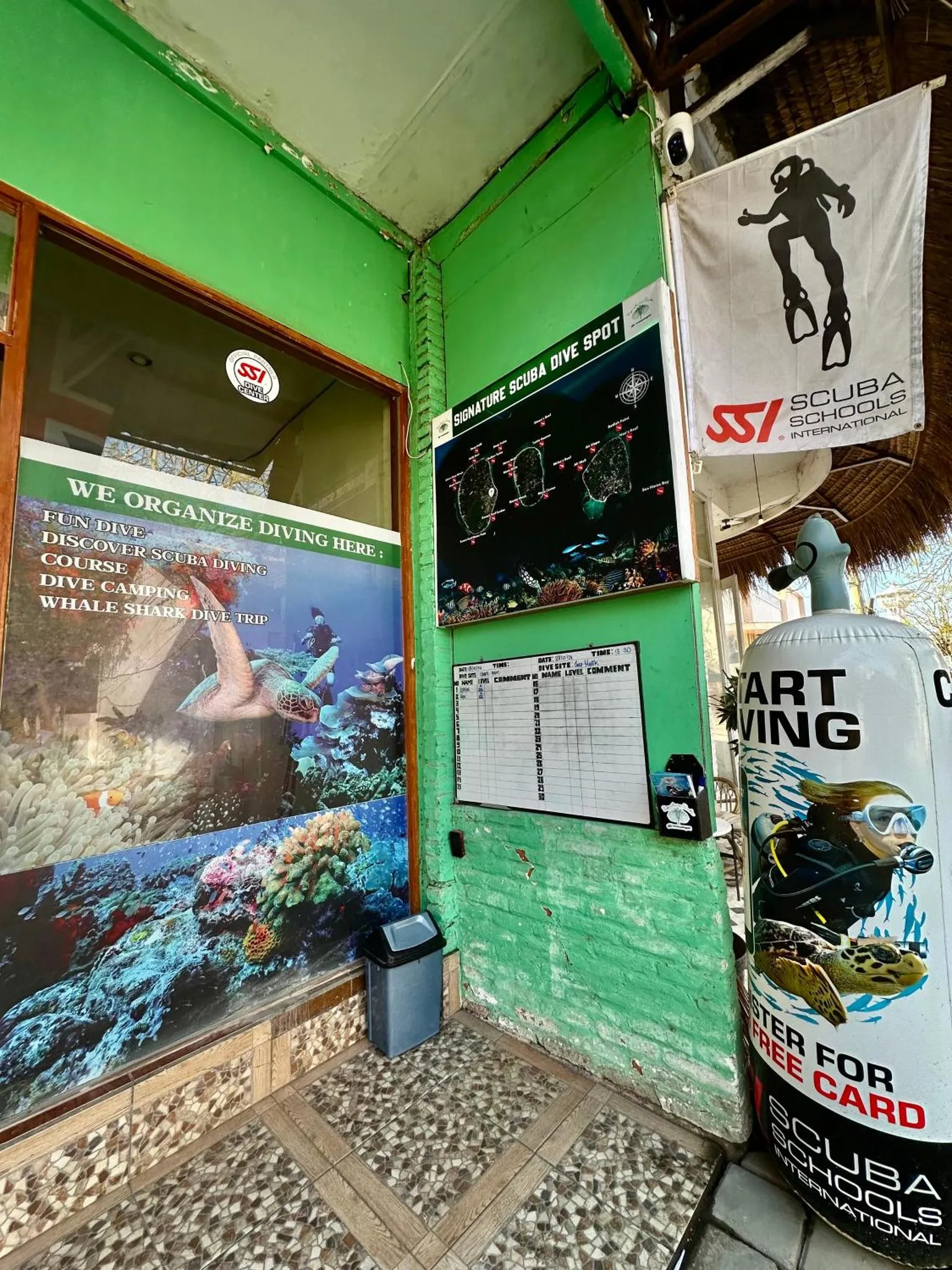 Façade d'un bâtiment vert avec des affiches et une fenêtre.