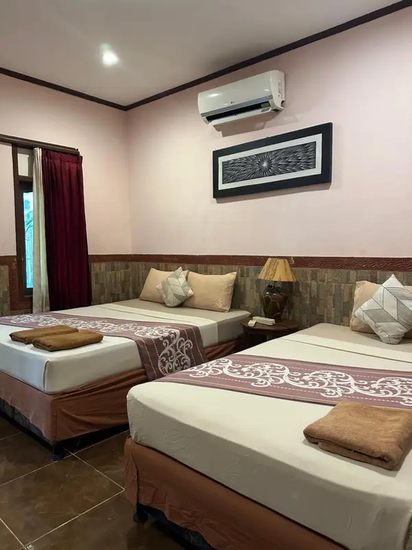 Chambre avec deux lits simples et décoration murale.