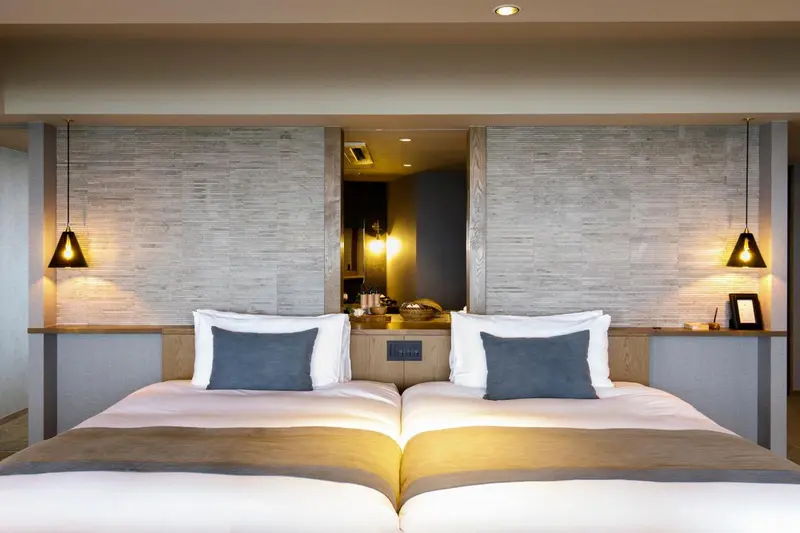 Un lit double avec des oreillers bleus et blancs dans une chambre moderne.