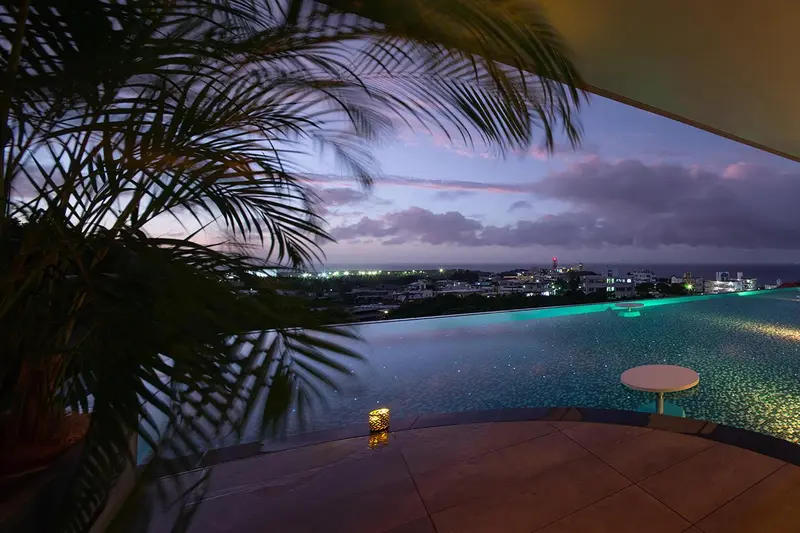 Vue sur la mer au crépuscule depuis une piscine à débordement.