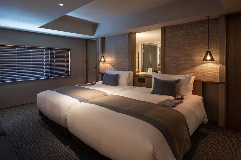 Une chambre avec deux lits simples et un éclairage tamisé.