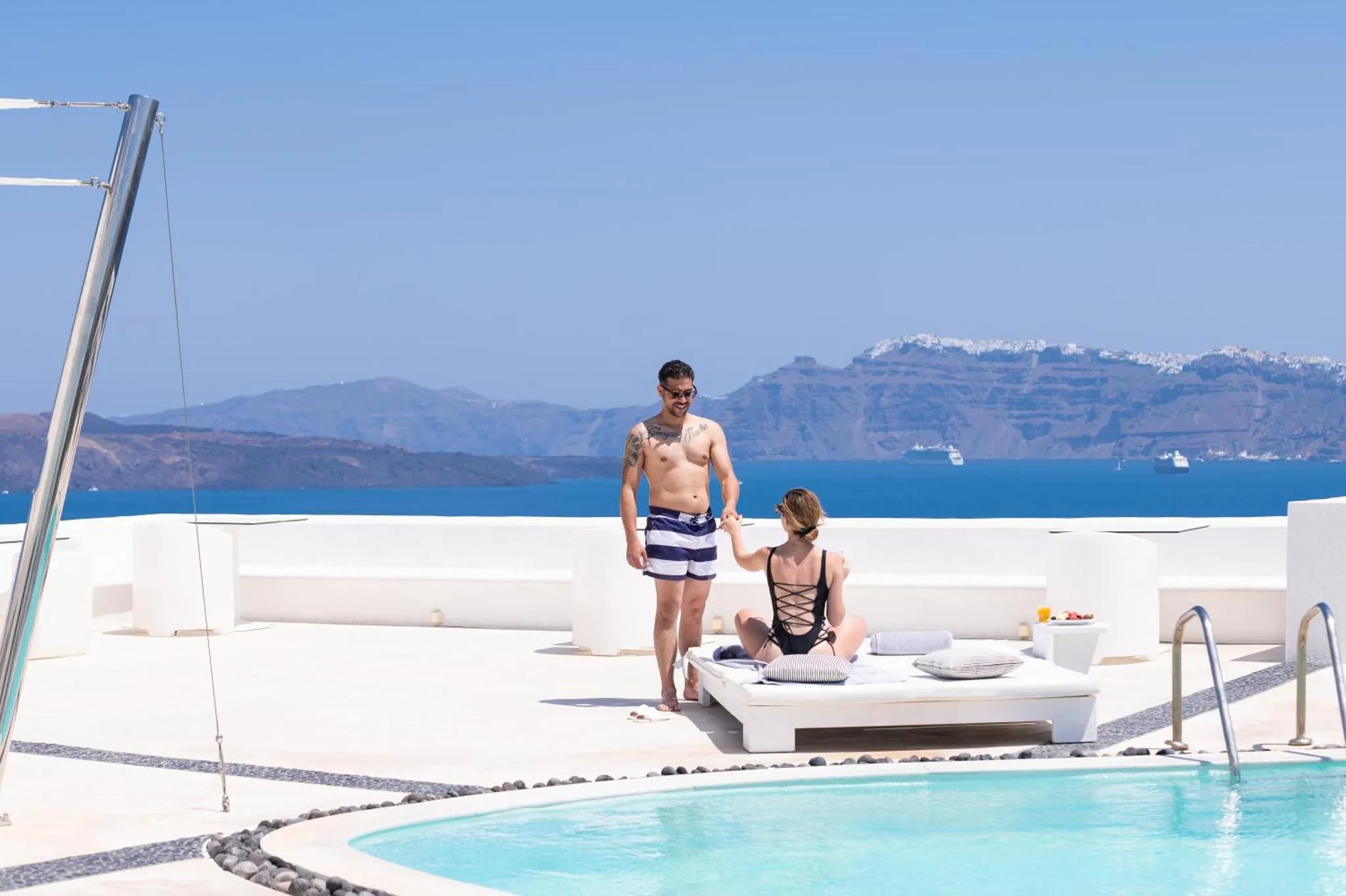 Un couple se détend sur une terrasse avec vue sur la mer.