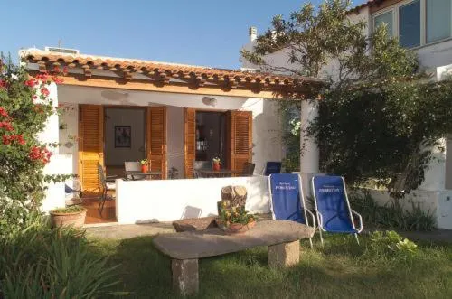 Terrasse ombragée avec mobilier de jardin et végétation luxuriante.