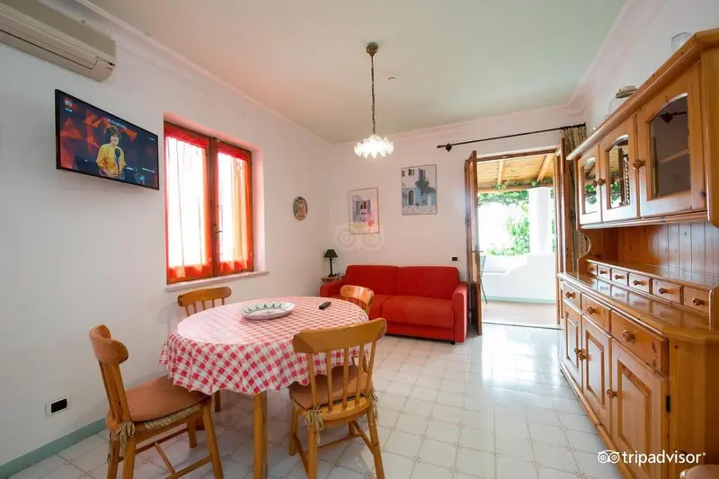 Une pièce lumineuse avec une table à manger et un canapé rouge.
