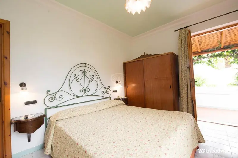 Une chambre lumineuse avec un lit recouvert d'une courtepointe et une armoire en bois.