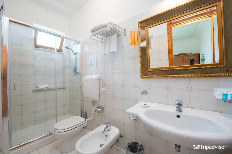 Une salle de bain claire avec douche et lavabo.