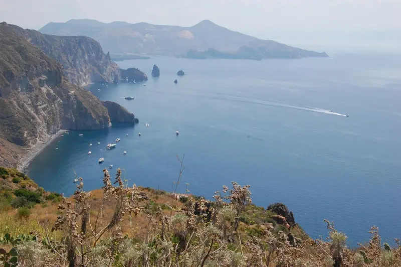 Vue panoramique sur une côte rocheuse et la mer bleue.