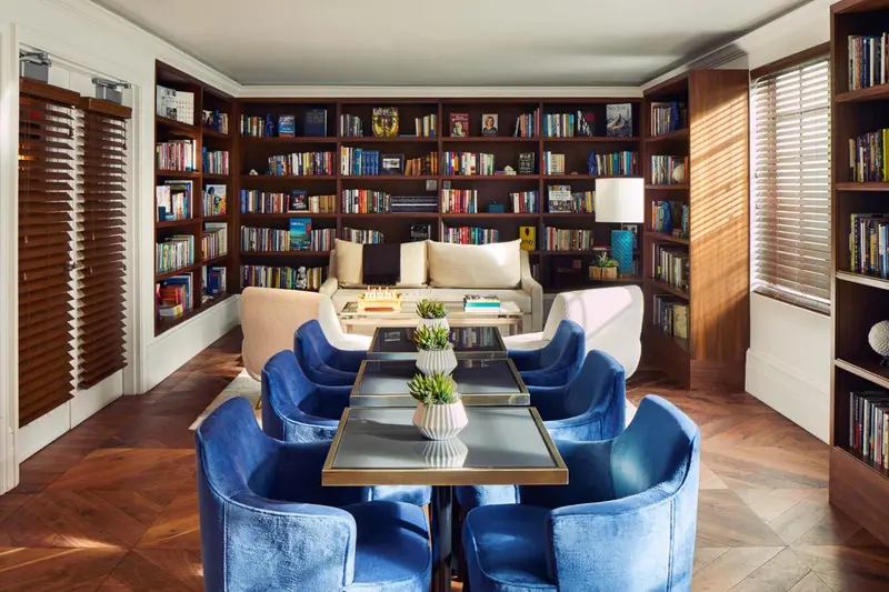 Un salon chaleureux avec des bibliothèques remplies de livres et des fauteuils confortables.