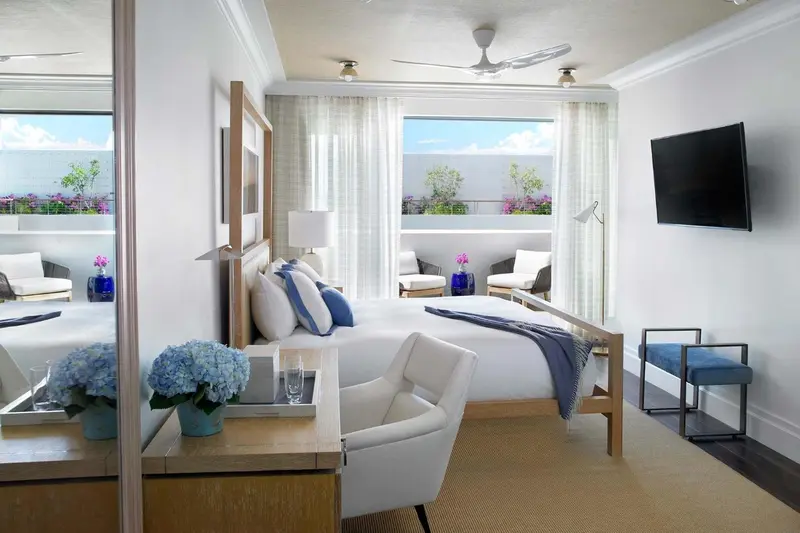 Une chambre lumineuse avec un grand lit et un coin salon.