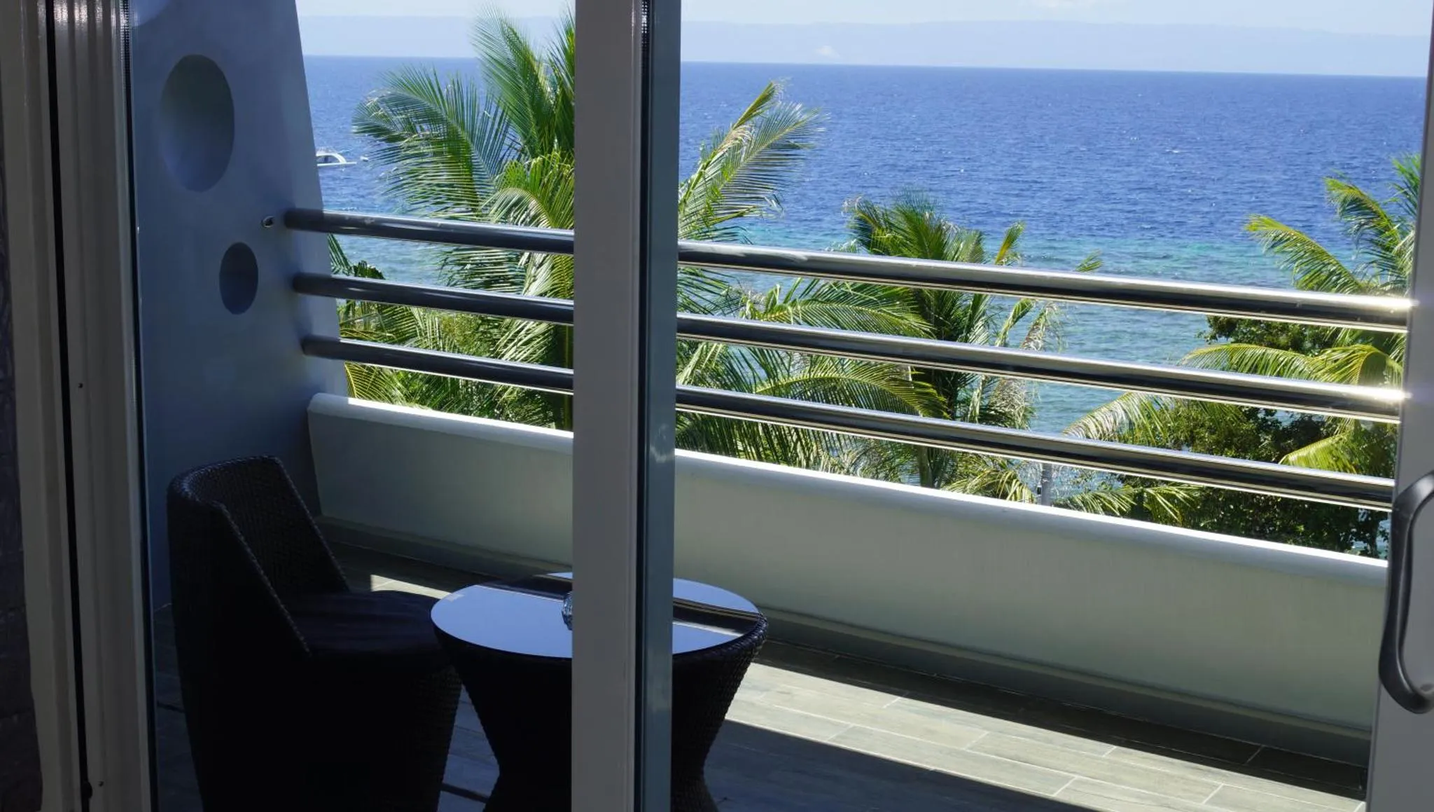 Vue sur la mer depuis une terrasse avec mobilier d'extérieur.