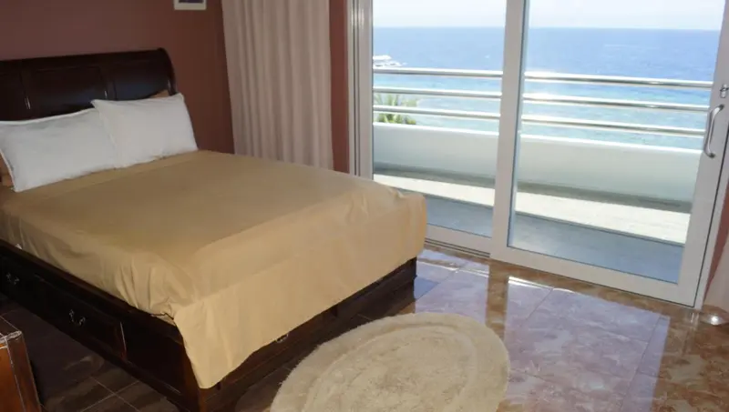 Une chambre avec un grand lit donnant sur une vue mer.