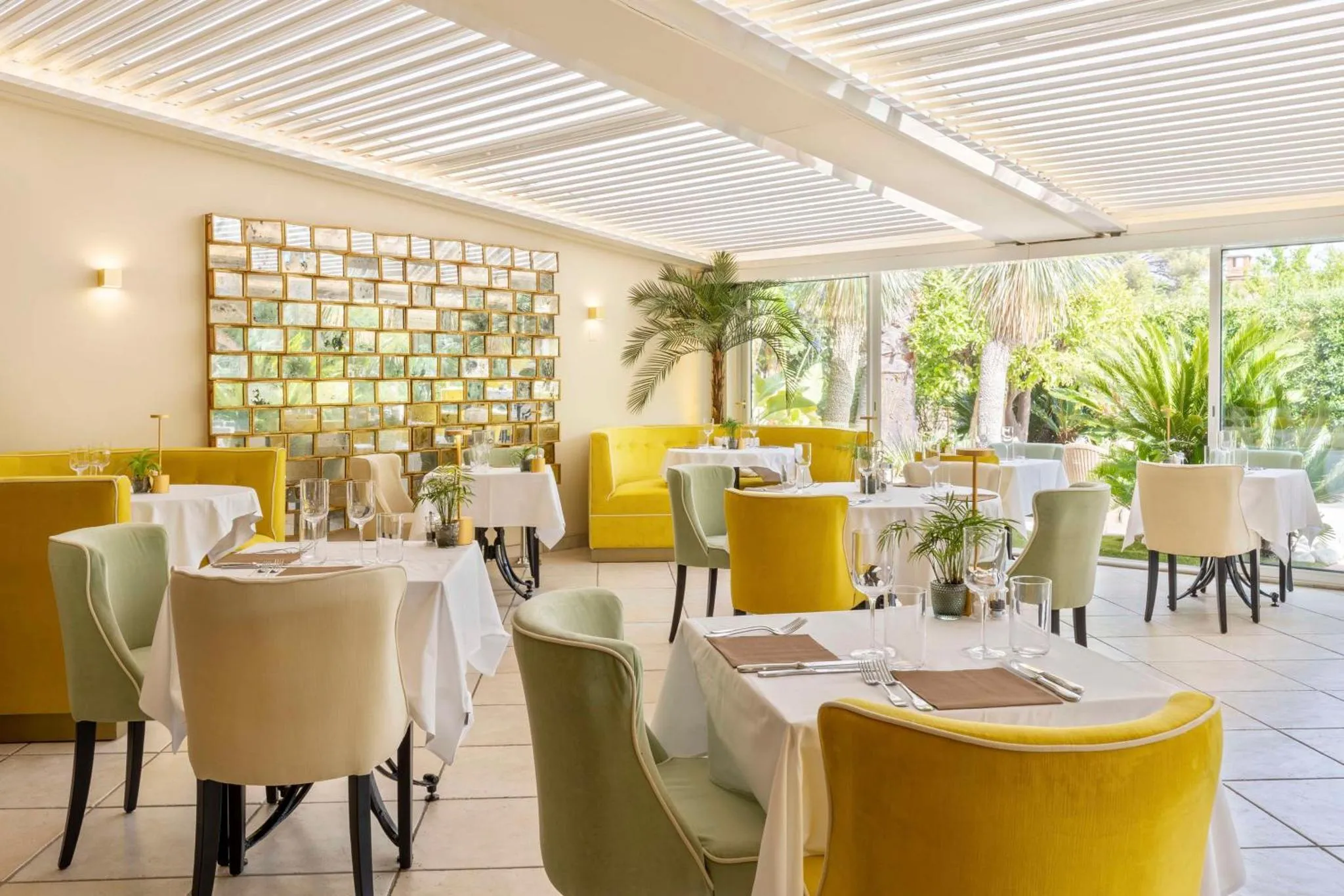 Une salle lumineuse avec des tables dressées pour un repas.
